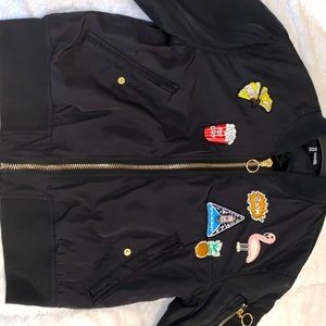 Girls black bomber jacket with patches on the front and arms